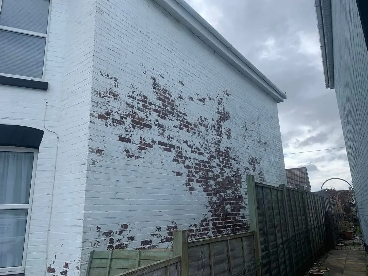 Peeling paint on a brick wall before redecoration in Bovey Tracey